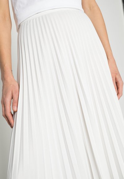 Jupe plissée blanche en tissu lisse. Présente des plis verticaux régulièrement espacés et une taille ajustée, avec une texture douce.