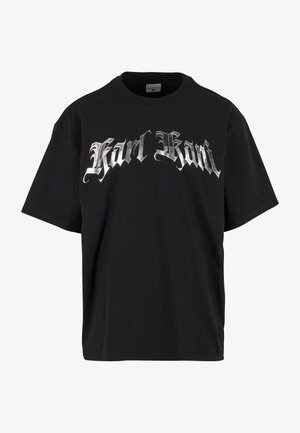 Schwarzes Baumwoll-T-Shirt mit kurzen Ärmeln und einem Rundhalsausschnitt. Mit großen silbernen gotischen Buchstaben "Karl Kani" über der Brust.