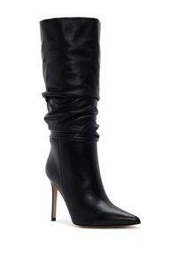 Bota de cuero negra hasta la rodilla con un diseño arrugado, punta afilada y tacón de aguja. Textura suave y acentos minimalistas.