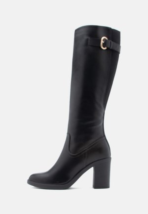 Botas pretas até ao joelho feitas de couro liso, com salto bloco, forma contornada e uma tira decorativa com fivela metálica.