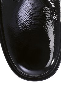 Scarpa in pelle verniciata nera con finitura lucida, punta arrotondata e texture liscia. Nessun motivo visibile o dettagli hardware.