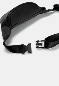 Geantă de talie din nylon negru, cu un buzunar curbat cu fermoar, curea reglabilă și închidere cu cataramă din plastic. Textură netedă, design minimalist.