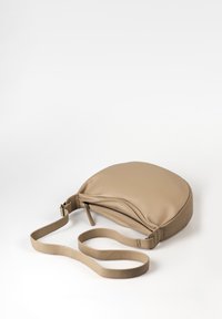 Beige Leder Umhängetasche mit runder Form, Reißverschluss und einem langen, flachen Tragegurt. Sanfte Textur, minimalistisches Design.