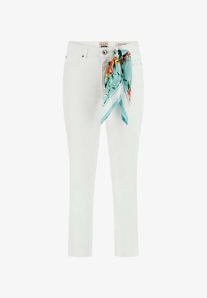 Witte skinny jeans met een turquoise bloemige sjaal vastgeknoopt aan de voorste riemlus.