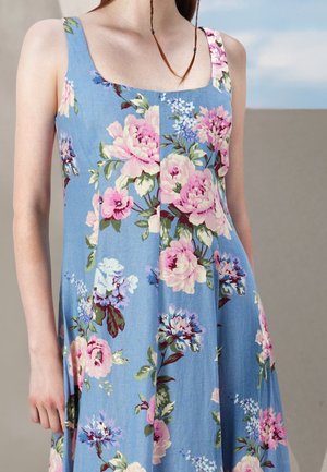 Kwiatowa sukienka z lekkiego niebieskiego materiału. Posiada różowe piwonie i niebieskie kwiaty w luźnym kroju z cienkimi ramiączkami i kwadratowym dekoltem.