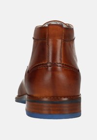Bruine leren enkellaarzen met een gladde afwerking, voorzien van een blauwe rubberen zool en contrasterende stiksels langs de achterkant en de hak.
