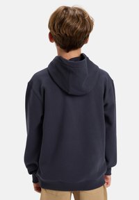 Navy blue hooded sweatshirt with a relaxed fit, ribbed cuffs, and hem. Soft texture, minimal detailing, and large attached hood at the back.
