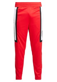 Röda sportbyxor med en avsmalnande design, med svarta och vita sidopaneler, elastiskt midjeband och slät, lättviktig tyg.