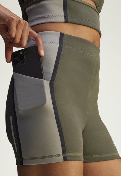 Hoge taille sportshorts in olijfgroen met zwarte en grijze accenten. Voorzien van een zijzak voor een smartphone en contrasterende stiksels.