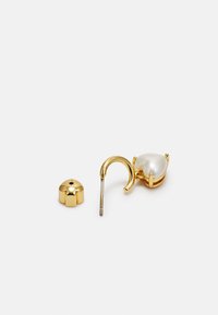 Gold heart-shaped earring with a large white pearl, featuring a hook closure and a decorative backing with a rounded shape.