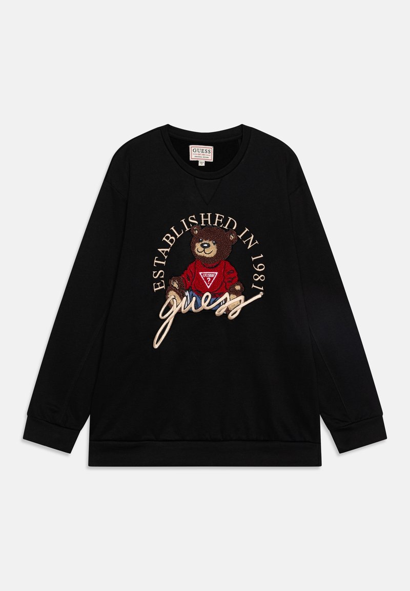 Sweat-shirt noir à manches longues avec un graphisme d'ours brodé, le texte "GUESS" et la mention "Established in 1981" en accents beige et blanc. Tissu doux.