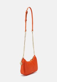 Orange faux leather handbag with a curved shape, gold chain and leather strap, and a zip closure, featuring a decorative charm.