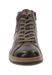 Zapato alto de cuero marrón con cordones grises, un zipper expuesto en el lado y una suela de goma beige. Textura suave con acentos perforados.