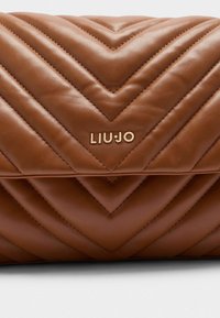 Brązowa pikowana skórzana torba w wzór chevron. Posiada złote logo LIU·JO z przodu, tworząc elegancki detal.