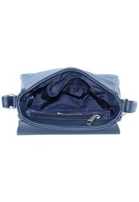Innenansicht einer marineblauen Lederhandtasche mit glatter Textur, einem Reißverschlussfach und einem geräumigen Hauptfach mit Stoffauskleidung.