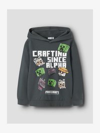 Sudadera con capucha de Minecraft en gris oscuro con el texto "Crafting Since Alpha" y personajes del juego pixelados, incluyendo Creepers, lobos y un pollo.