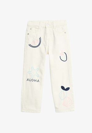 Pantalons en denim couleur crème avec des designs brodés incluant une étoile de mer, des fruits et le mot "ALOHA" dans des couleurs navy et pastel.