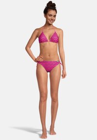 Bikini rose à motif zigzag avec un haut triangulaire et un bas à liens ajustables sur les côtés. Fabriqué en matériau lisse et extensible.