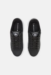 Fekete fűzős sneaker, bőr és szövet kombinációjából készült, fehér talppal, logóval ellátott foltokkal és textúrált fűzőkkel a tapadásért és a stílusért.