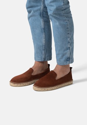 Scarpe slip-on in suede marrone con punta tondeggiante, suola in giuta intrecciata e design ritagliato sui lati. Indossate con jeans blu chiari a vita alta.