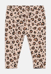 Beige legice za malčke z črnimi in rjavimi srčkastimi leopardjimi pikami ter majhnimi logotipi "Guess", natisnjenimi po celotni površini.