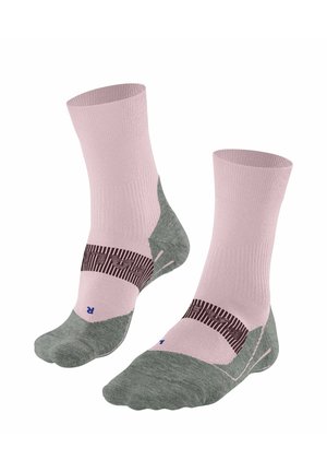 Par pink og grå sportssokker med mørkt stribedesign og markerede venstre og højre fodområder på hvid baggrund.