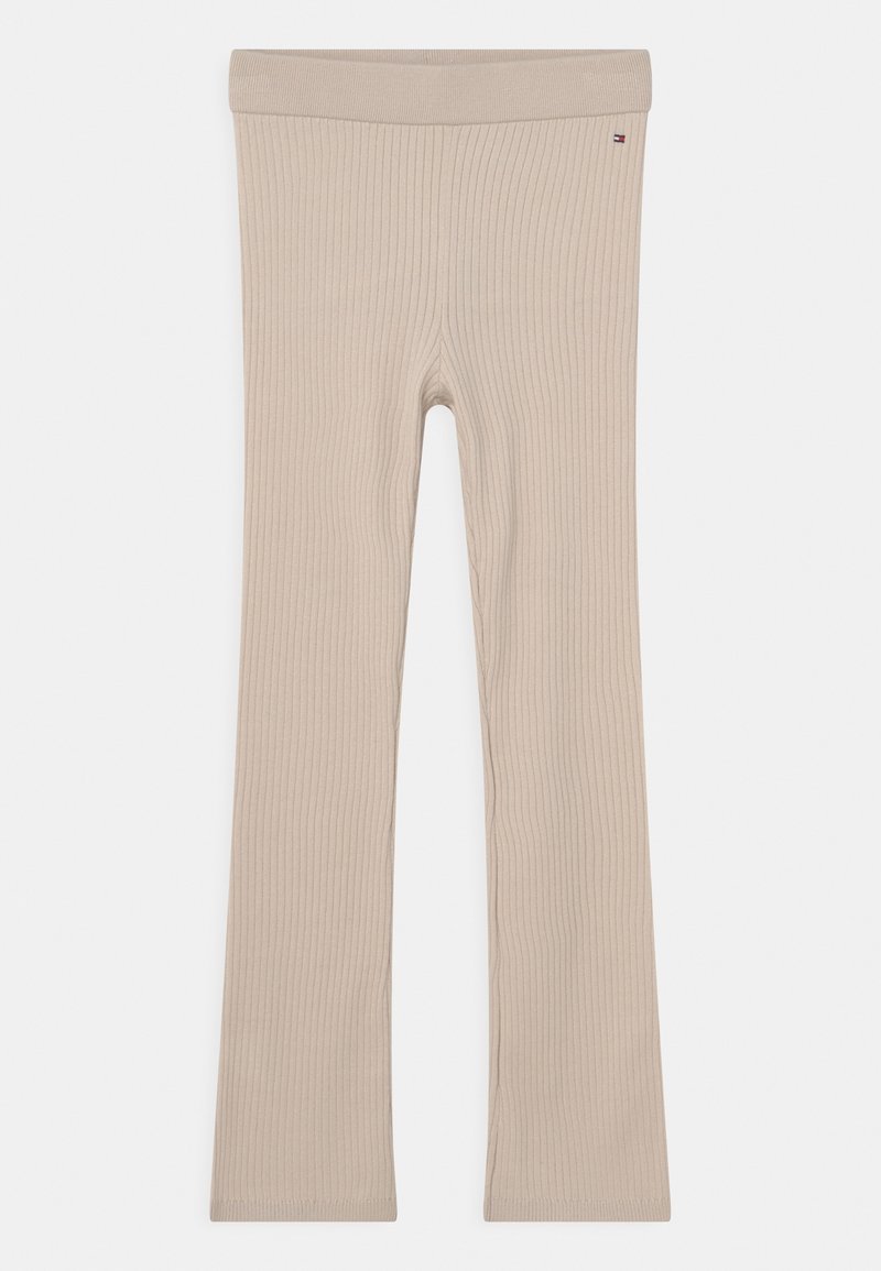Beige gerippte Strickleggings mit leicht ausgestellten Beinen und kleinem Tommy Hilfiger Flaggenlogo in der Nähe des Bundes auf weißem Hintergrund.