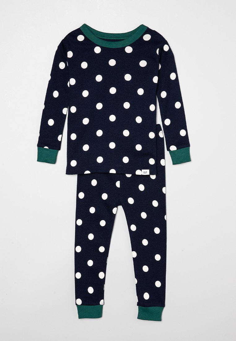 Ensemble de pyjama en coton bleu marine avec des pois blancs. Haut à manches longues avec des poignets verts, le pantalon assorti présente également des pois et des ourlets verts aux chevilles.