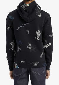 Svart hoodie med olika grafiska motiv som kors, lågor och spindelnät. Mjuk textur med en avslappnad passform och dragsko i huvan.