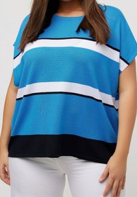 Pohodlný top s krátkým rukávem ve volném střihu v odstínech modré s bílými a černými vodorovnými pruhy. Měkká tkanina, kulatý výstřih, volně splývá.