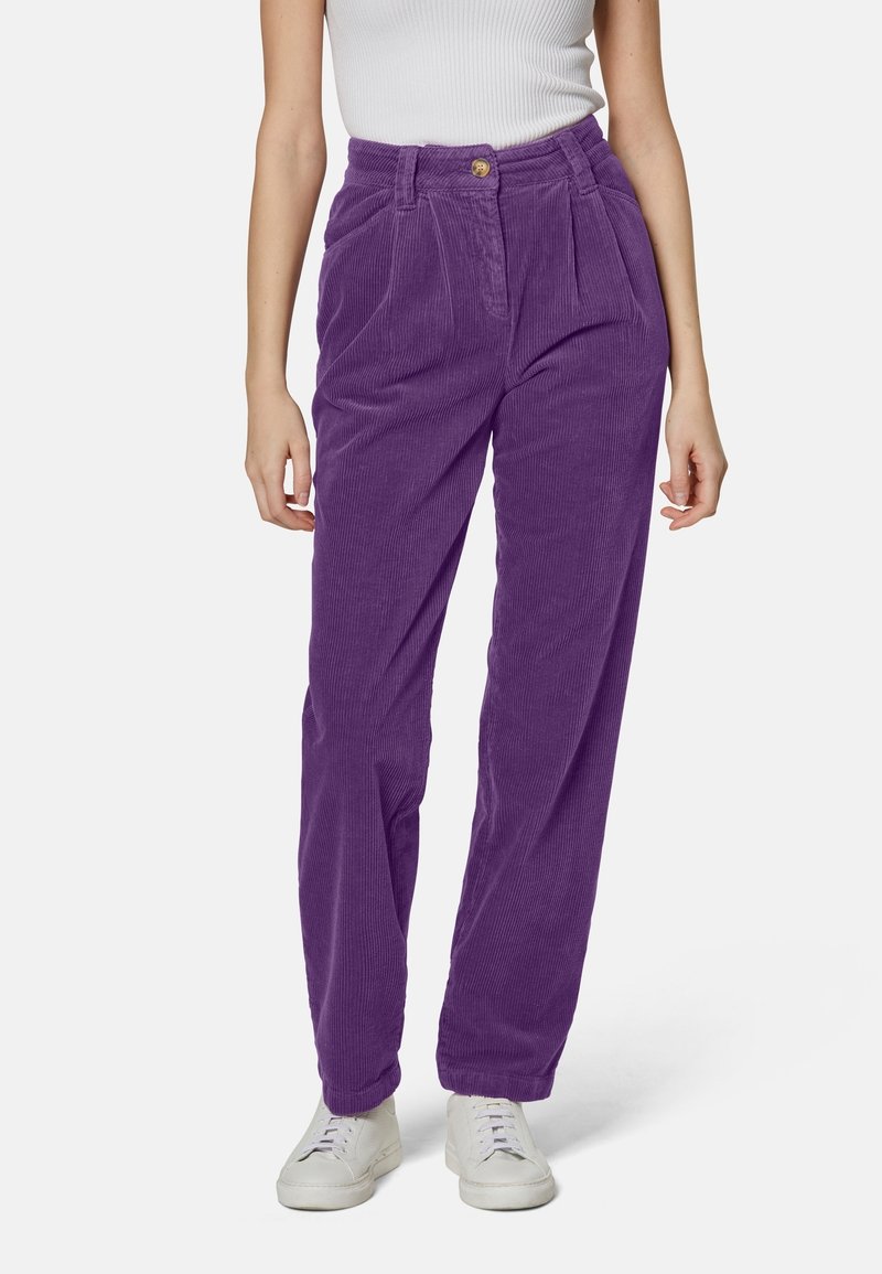 Pantaloni in corduroy viola con vita alta, pieghe e chiusura con bottone; abbinati a sneakers bianche. Texture morbida e design a gamba dritta.