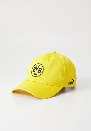 Żółta czapka z zaokrąglonym daszkiem, z okrągłym czarnym logo z napisem "BVB 09" z przodu oraz małym logo Pumy z boku.
