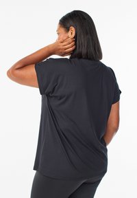 Černý krátký rukáv top z hladké, lehké látky. Volný střih s kulatým výstřihem, s prošitými lemy a zaobleným zadním spodním okrajem.
