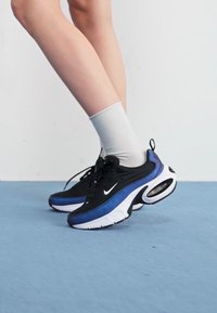 Black and blue athletic shoes with air cushioning, white accents, and textured materials; laced with rounded toe and supportive sides.