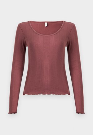 Langermet topp i støvete rosa, ribbestruktur, rund halsutringning, bølget kant nederst og på mansjettene, laget av mykt strikkemateriale.