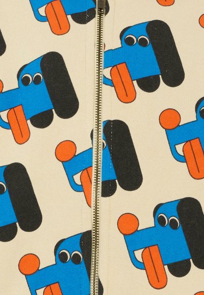 Motivo di cani cartoni animati blu su tessuto beige, con grandi orecchie nere, occhi circolari e accenti arancioni. Cerniera che corre al centro.