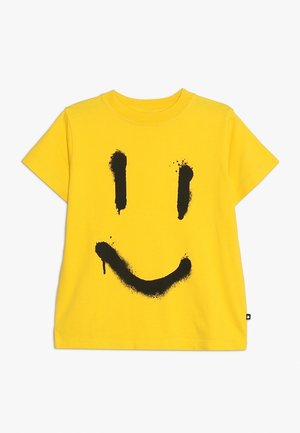 Gul t-shirt med korte ærmer med et sort spraymalet smiley-ansigt, der har to lodrette øjne og en buet mund.