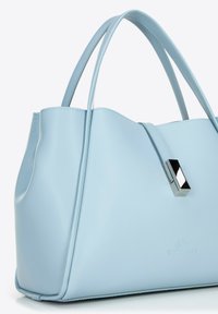 Jasnoniebieska torebka wykonana z gładkiej skóry, z dwiema krótkimi rączkami, akcentami w srebrnym kolorze oraz wytłoczonym logo marki z przodu.