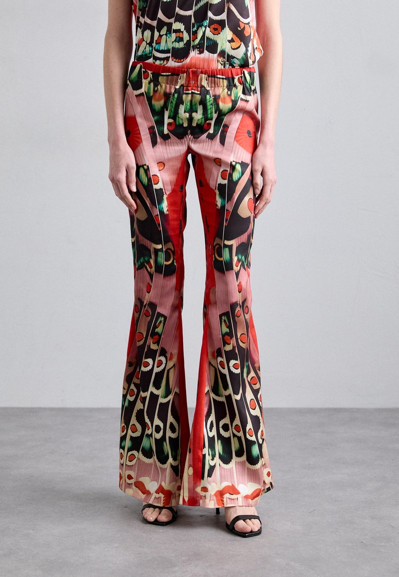 Pantalons évasés de couleur rouge vif, ornés de motifs complexes d'yeux et de formes abstraites. Fabriqués en tissu doux avec une taille élastique.