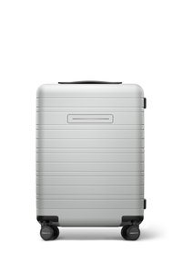 Silver hard-shell suitcase with horizontal ridges, black wheels, and a top handle. Sleek design, rectangular shape, minimalist features.