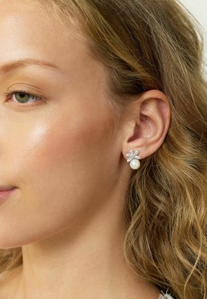 Pearl earrings featuring a floral design with sparkling accents. The earrings are set in a metallic finish.