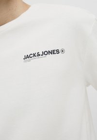 Witte katoenen T-shirt met een ronde hals, korte mouwen en een zwart gedrukt logo op de borst met de tekst "JACK & JONES ®."