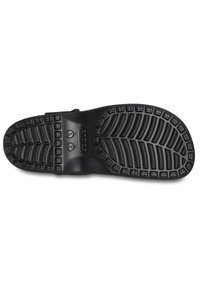 Zwarte rubberen zool met een gestructureerd oppervlak. Bevat een profielpatroon voor grip, inclusief verhoogde secties en een glad centraal gebied.