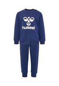 Granatowy dres wykonany z miękkiego materiału, z okrągłym dekoltem i białym logo na bluzie, oraz dopasowanymi spodniami ze ściągaczami.