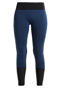 Leggings blu navy con vita nera, caratterizzati da dettagli testurizzati neri nella parte inferiore delle gambe. Realizzati in tessuto elasticizzato.