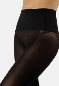 Leggings neri opachi con vita alta. Caratterizzati da una texture liscia e un design senza cuciture, offrono un look aderente e comfort.