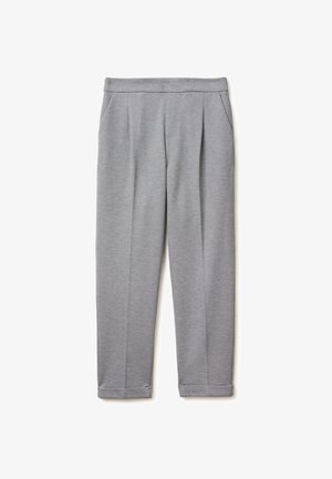 Jasnoszare spodnie o prostych nogawkach, z płaskim przodem, bocznymi kieszeniami i podszytymi mankietami na białym tle.