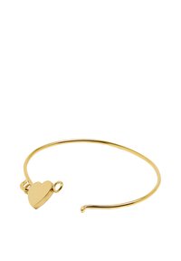 Złoty metalowy bransoletka typu bangle z małym zawieszką w kształcie serca, o gładkiej, polerowanej fakturze i otwartym kształcie.