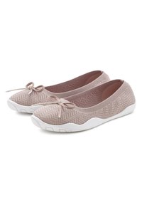 Bailarinas de color rosa claro con textura de punto, que presentan un lazo en la parte delantera y una suela de goma blanca con un patrón texturizado.