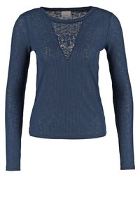 Haut bleu à manches longues côtelé avec une insertion triangulaire en dentelle au niveau de l'encolure. Fabriqué en matériau léger avec une finition texturée.